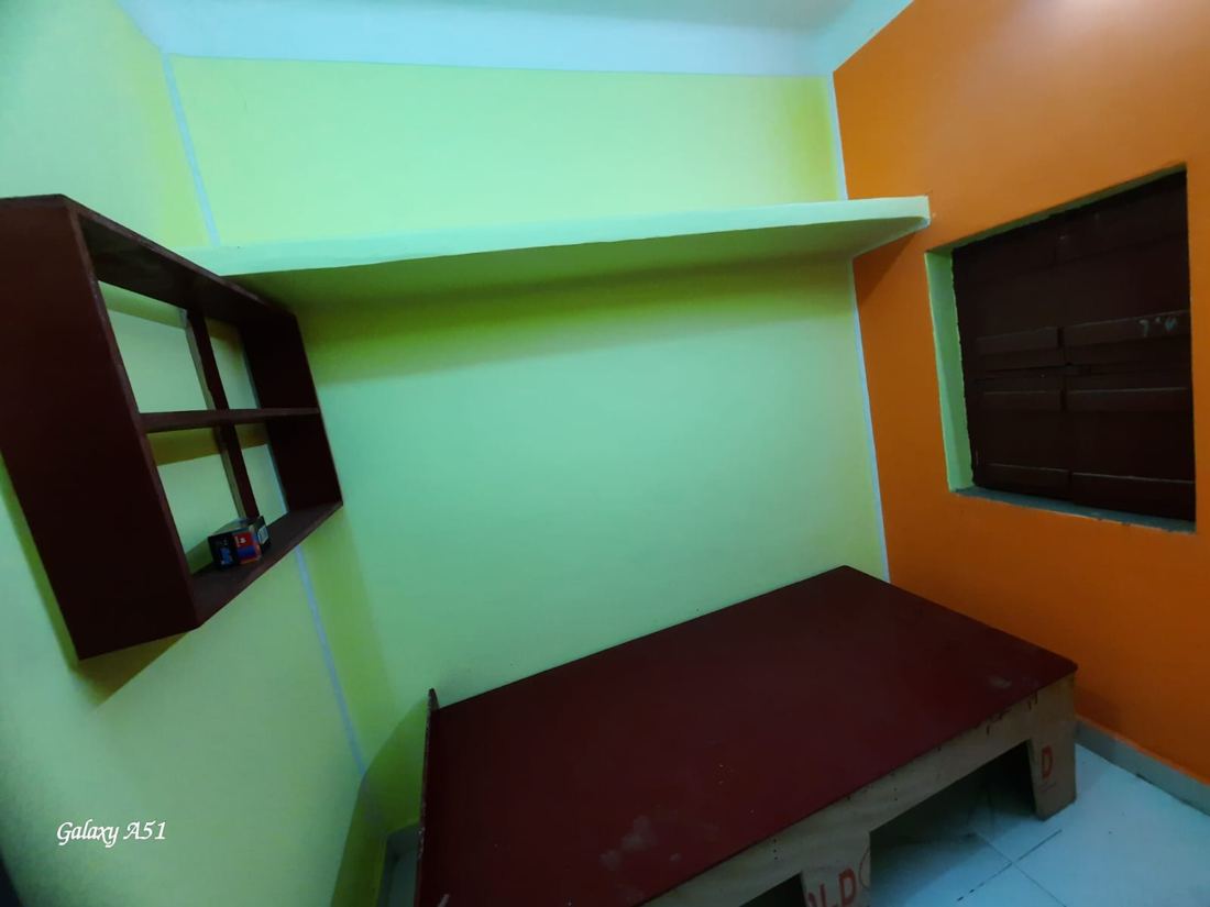 Bright room with orange wall, two windows and beds